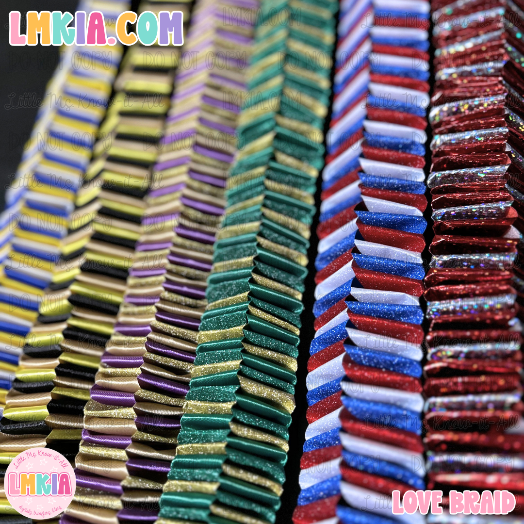 Stacks of decorative braid hair ties in multiple colors, including gold, green, blue, red, and white, arranged vertically. The brand name 'LMKIA' is visible in the top left corner and bottom left circular logo, and 'LOVE BRAID' is written in the bottom right corner.